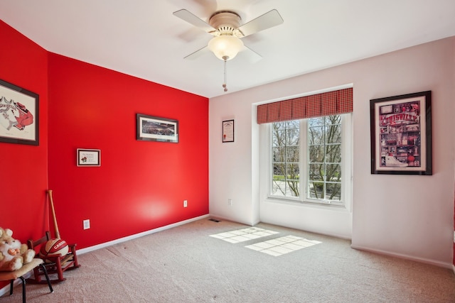 empty room featuring ceiling fan, baseboards, and carpet