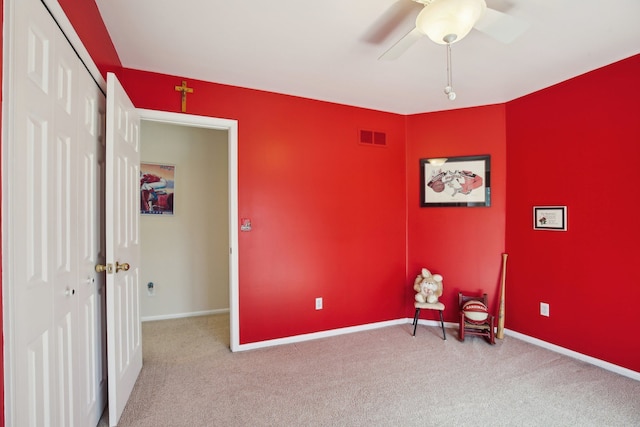 living area featuring baseboards, a ceiling fan, carpet flooring, and visible vents