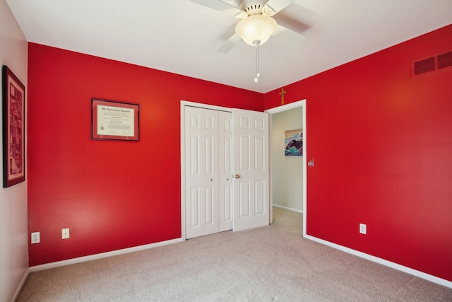 unfurnished bedroom featuring carpet flooring, baseboards, visible vents, and a closet