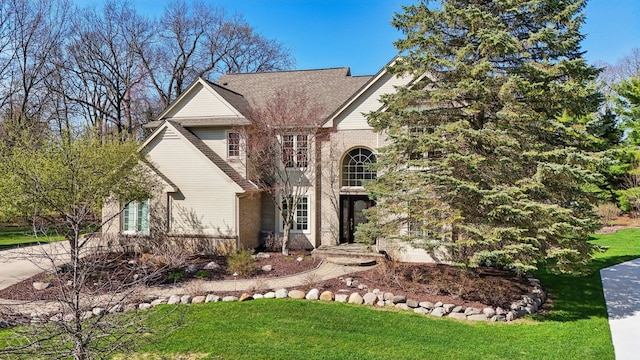 view of front of house featuring brick siding and a front yard