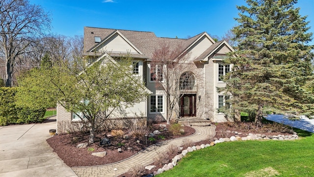 traditional home featuring a front lawn and brick siding