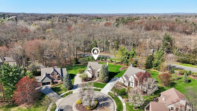 drone / aerial view with a residential view and a wooded view