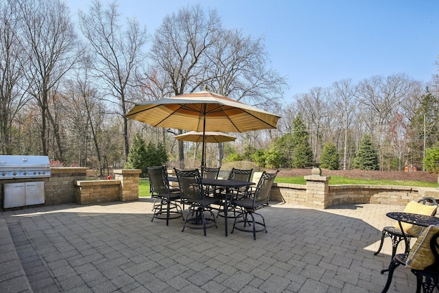 view of patio with outdoor dining space, a grill, and area for grilling