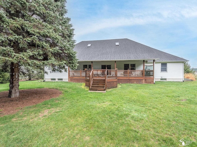 back of house featuring a lawn, a deck, and a shingled roof