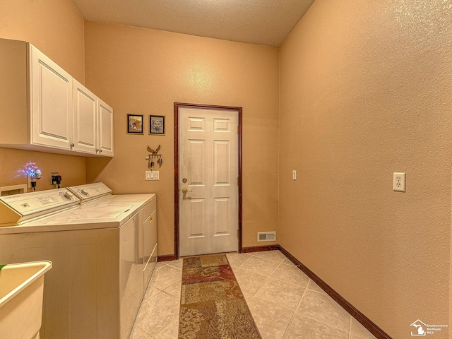 clothes washing area with washing machine and clothes dryer, visible vents, cabinet space, a textured wall, and light tile patterned floors