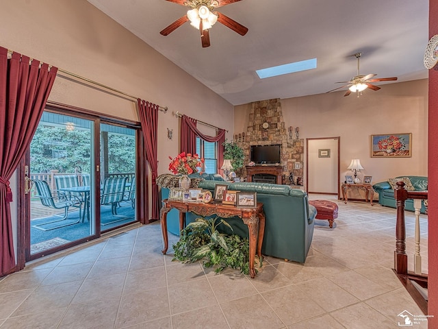 living room with a fireplace, high vaulted ceiling, ceiling fan, and light tile patterned floors