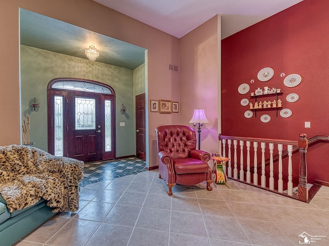 foyer entrance featuring visible vents, tile patterned flooring, and baseboards