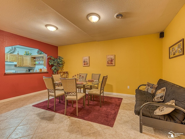 dining space featuring visible vents and a textured ceiling
