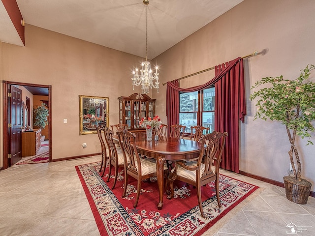 dining area with baseboards, a high ceiling, a notable chandelier, and light tile patterned floors