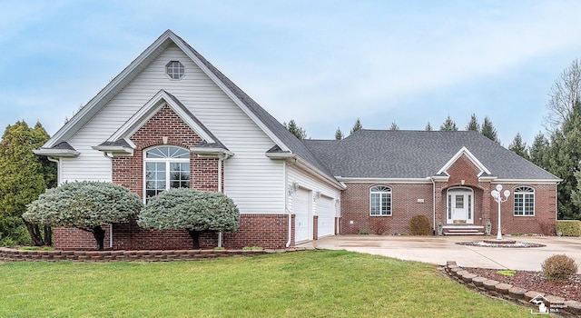 view of front of home with concrete driveway, a front lawn, and brick siding