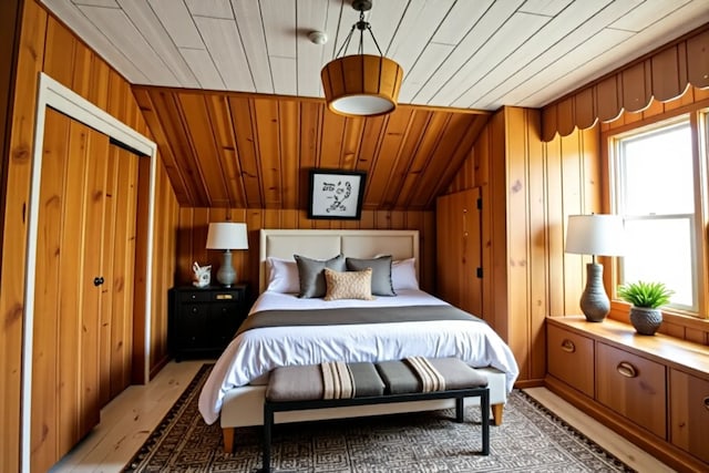 bedroom featuring wooden walls, light wood finished floors, wooden ceiling, and multiple windows