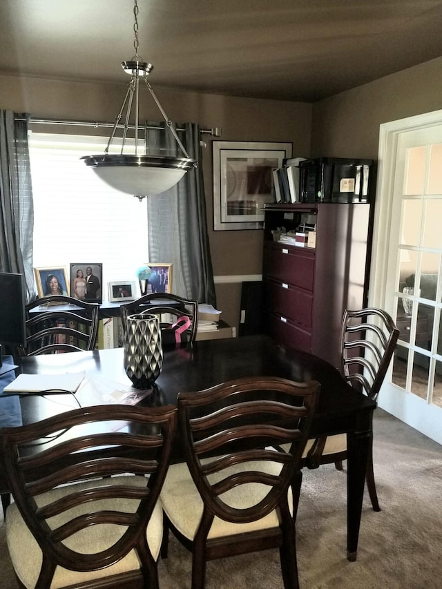 dining area with carpet and a chandelier