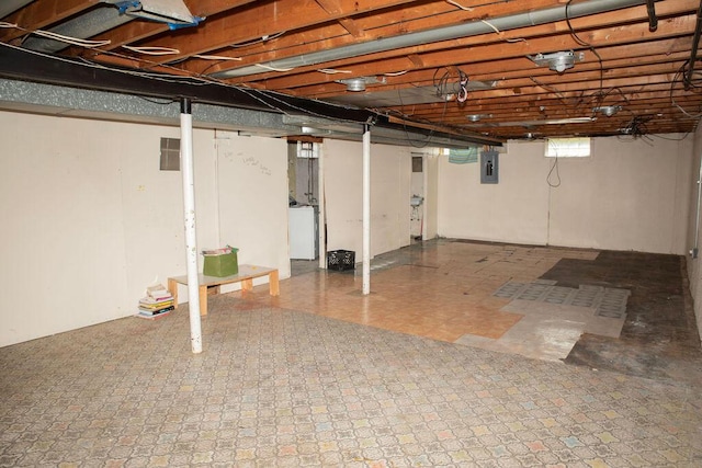 below grade area featuring washer / clothes dryer, tile patterned floors, and electric panel