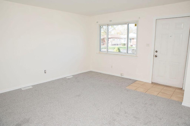 interior space featuring light colored carpet, baseboards, and visible vents