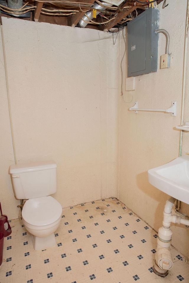 bathroom featuring toilet and electric panel
