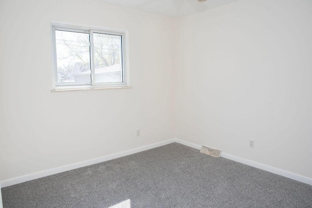 carpeted spare room with baseboards and visible vents