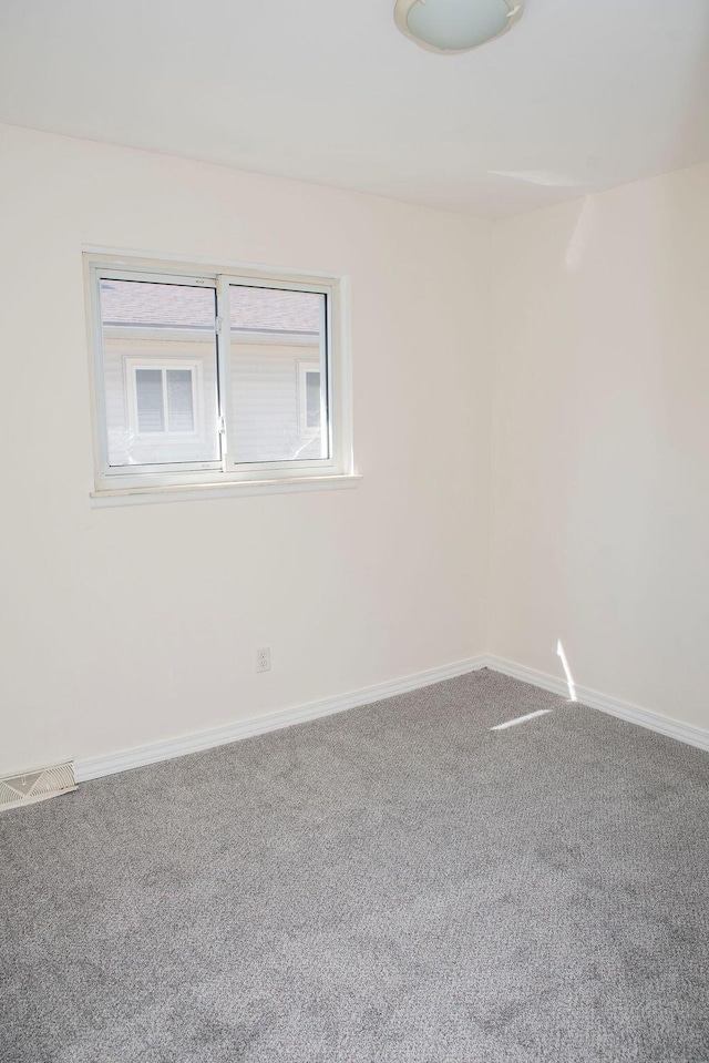 unfurnished room featuring carpet, visible vents, and baseboards