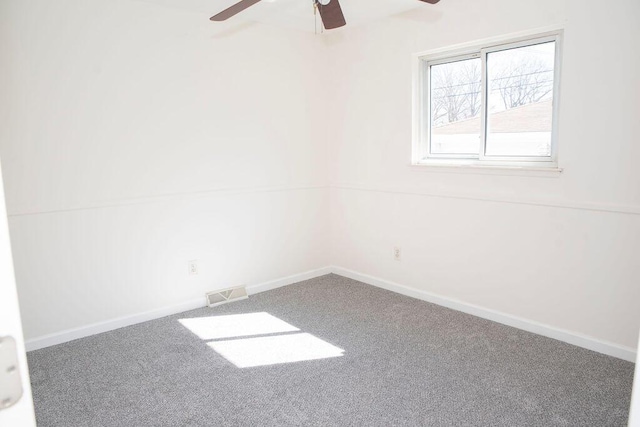 empty room featuring baseboards, visible vents, carpet, and ceiling fan