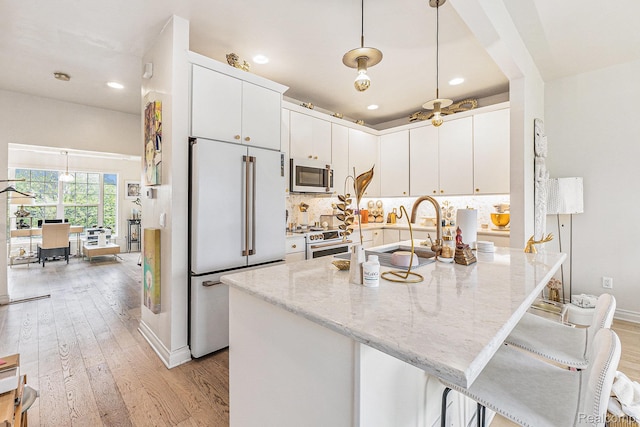4311 Miracles Blvd Unit 22, Detroit, MI 48201 - kitchen with white appliances, light wood-style floors, recessed lighting, a peninsula, and white cabinets