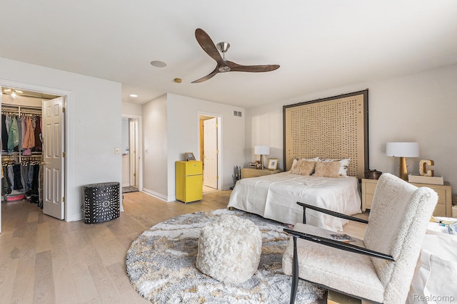 4311 Miracles Blvd Unit 22, Detroit, MI 48201 - bedroom featuring light wood-style flooring, a spacious closet, a closet, baseboards, and ceiling fan