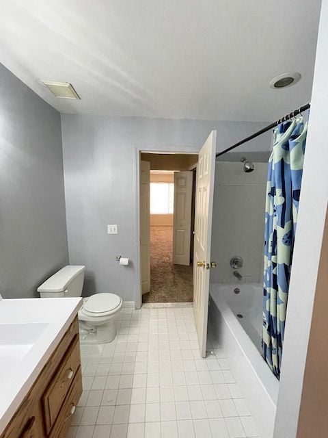 full bath featuring tile patterned floors, vanity, baseboards, toilet, and shower / bath combo with shower curtain