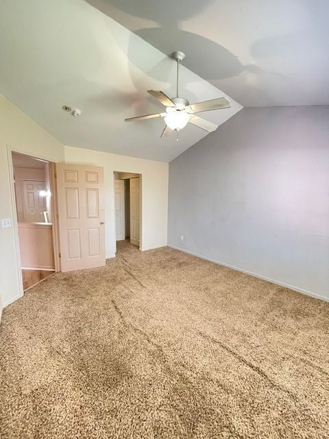 interior space with vaulted ceiling, baseboards, light colored carpet, a closet, and ceiling fan