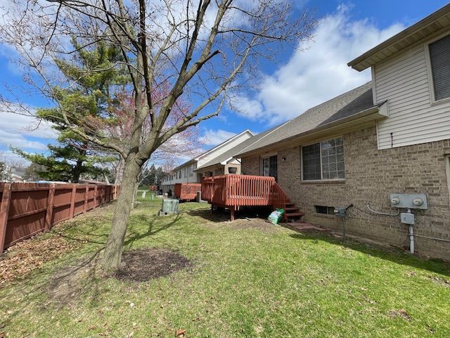 view of yard featuring fence and a deck