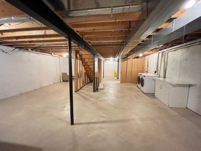 unfinished basement featuring washing machine and dryer and stairway