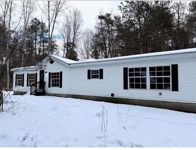 view of snowy exterior with crawl space