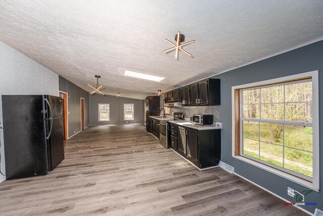 kitchen with light countertops, a textured ceiling, appliances with stainless steel finishes, and light wood finished floors