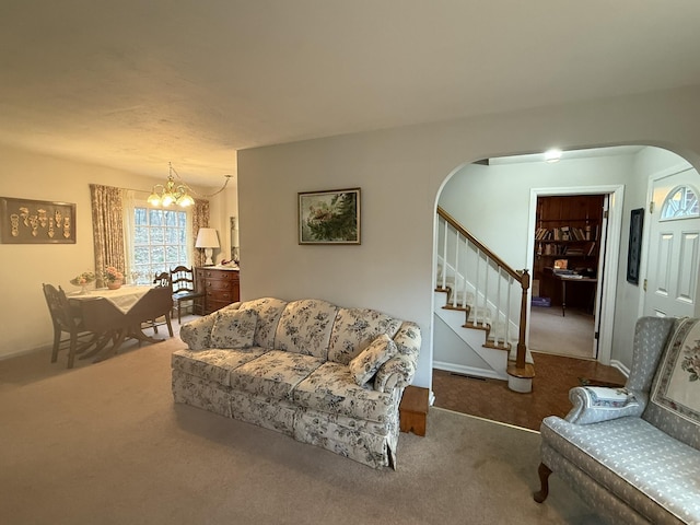living room with carpet flooring, arched walkways, visible vents, an inviting chandelier, and stairway