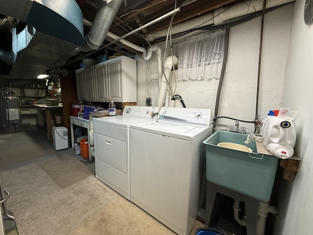 clothes washing area with cabinet space, gas water heater, and washing machine and clothes dryer