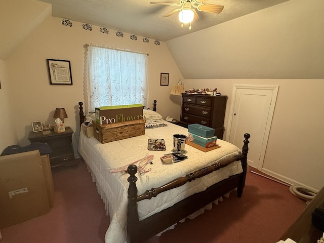 bedroom with lofted ceiling, dark colored carpet, and a ceiling fan