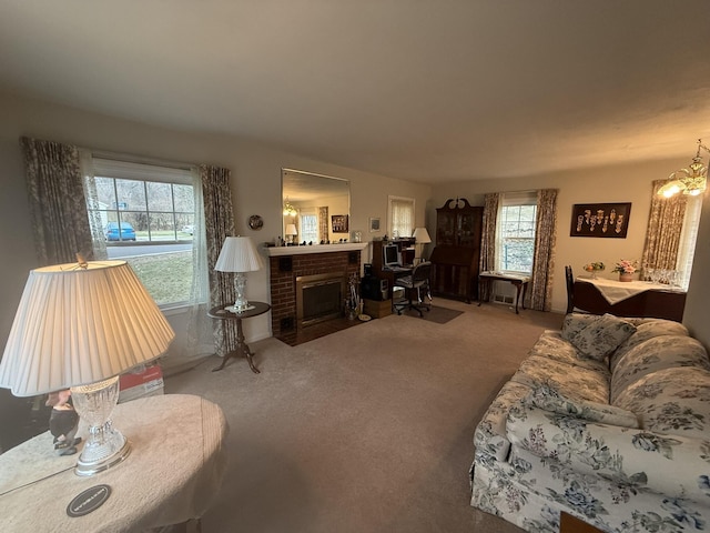 living area featuring a brick fireplace, carpet, and a notable chandelier