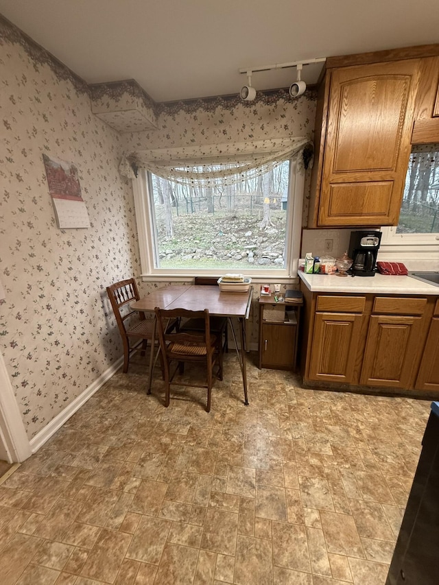 dining area featuring track lighting and wallpapered walls