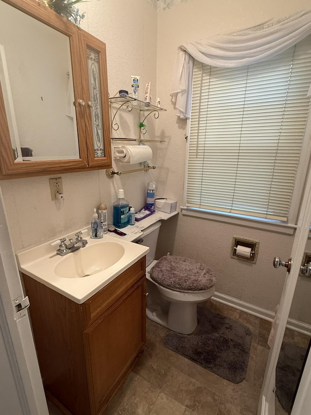 half bathroom featuring vanity and toilet