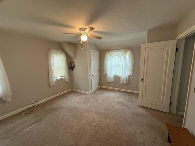 unfurnished bedroom with vaulted ceiling, baseboards, carpet, and a ceiling fan