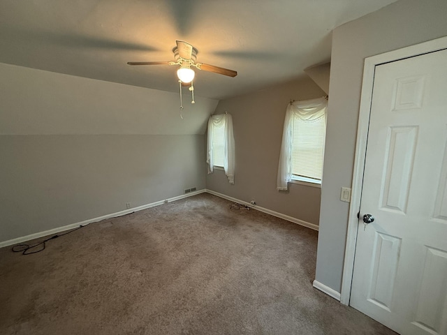 additional living space featuring vaulted ceiling, visible vents, a ceiling fan, carpet floors, and baseboards