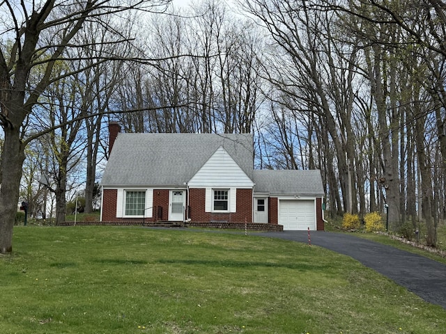 view of front of home featuring driveway, an attached garage, a front yard, brick siding, and roof with shingles
