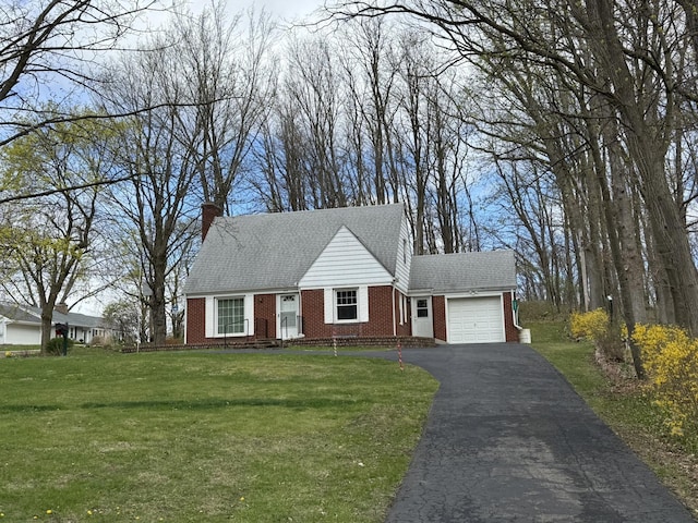 view of front of home featuring an attached garage, brick siding, aphalt driveway, and a front lawn