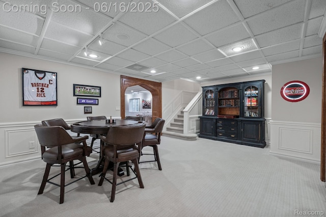 2010 W Valley Rd, Bloomfield Hills, MI 48304 - dining room featuring arched walkways, light colored carpet, a decorative wall, stairway, and a wainscoted wall