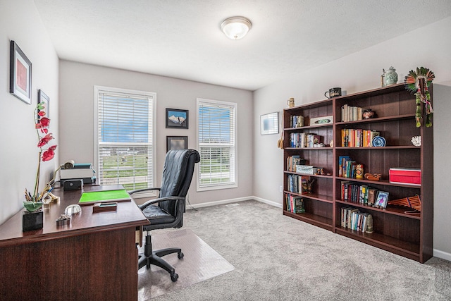 carpeted home office with baseboards