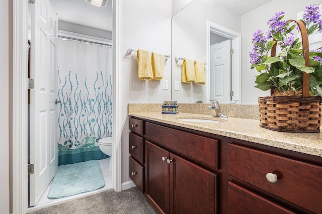 full bath with toilet, vanity, and curtained shower