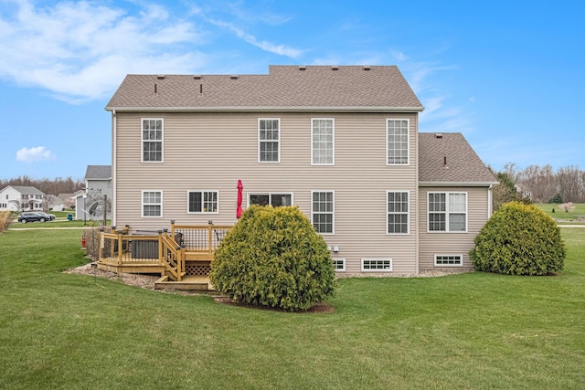 rear view of house with a wooden deck, a yard, and a shingled roof