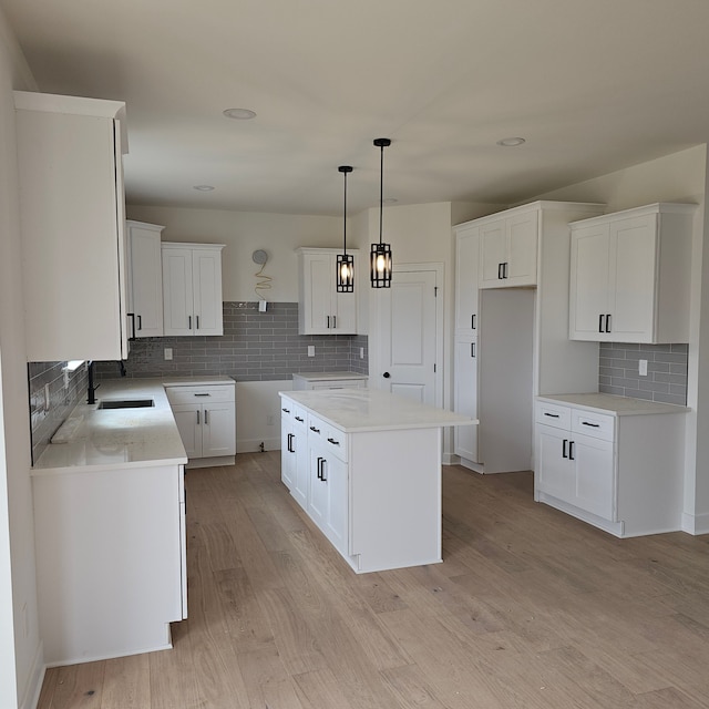 50638 Mistwood Dr, Macomb, MI 48042 - kitchen with a sink, backsplash, light wood finished floors, pendant lighting, and a kitchen island