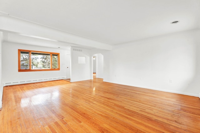 unfurnished living room featuring visible vents, arched walkways, baseboards, a baseboard heating unit, and light wood finished floors