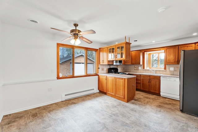 kitchen with a sink, light countertops, brown cabinets, a baseboard radiator, and stainless steel appliances