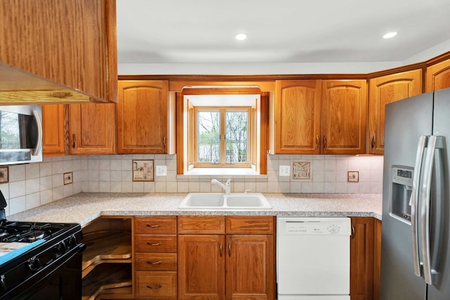 kitchen featuring a sink, light countertops, tasteful backsplash, and stainless steel appliances