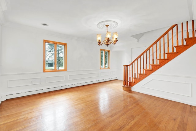 interior space featuring an inviting chandelier, a baseboard radiator, ornamental molding, and stairs