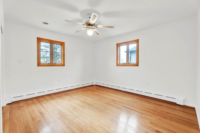 unfurnished room with baseboards, ceiling fan, baseboard heating, and wood finished floors